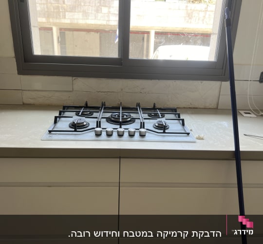 כיריים גז עם מברג על השיש ליד חלון